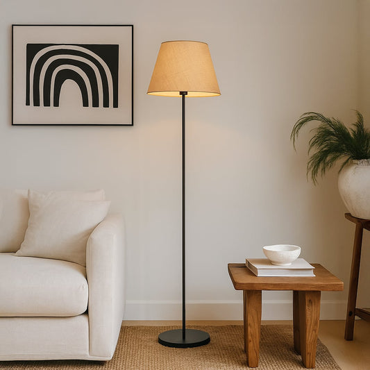 Beige floor lamp with fabric shade styled beside a modern sofa and wooden side table in a cozy living room setup.