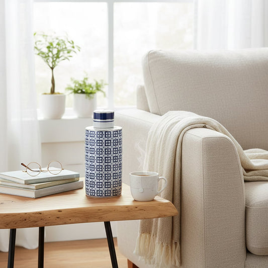 Blue ceramic decorative storage jar styled beside a sofa for elegant contemporary tabletop styling and home decor.