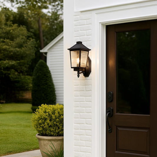 Traditional black metal wall lantern with ribbed glass panels mounted on ornate decorative bracket creating classic outdoor lighting style.