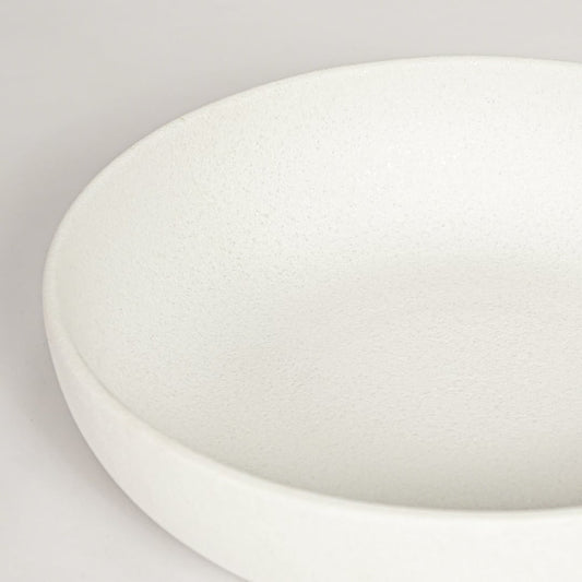 Closeup of matte white ceramic bowl with minimalist round shape ideal for elegant home decor shelf styling.
