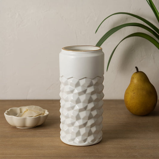 White textured ceramic vase with gold rim styled on a soft minimal background creating a modern decorative accent for shelves and consoles.