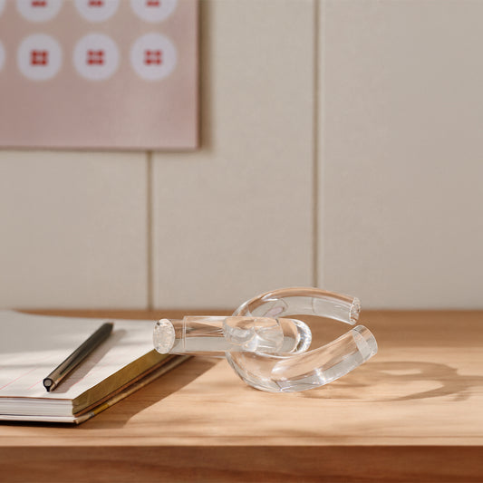 Clear glass decorative sculpture styled on a wooden console table for elegant contemporary home decor settings.