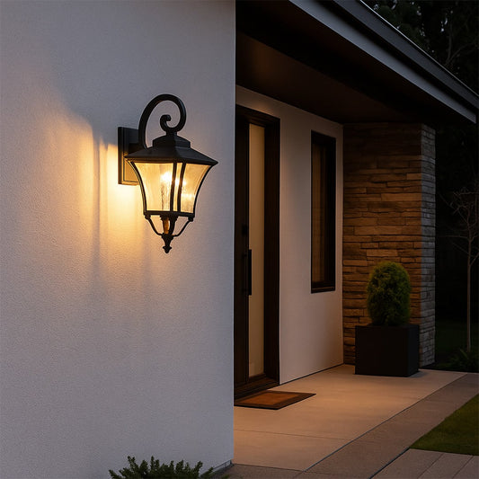 Elegant black outdoor wall lantern with clear textured glass adding warm ambient lighting to entryway or patio decor.