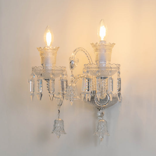 Decorative crystal wall light in clear finish with candle bulbs for living room or hallway decor lighting white background.