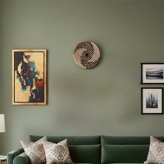 Handwoven round wall basket displayed above a green sofa adding natural texture and artisanal warmth to a modern living room wall.