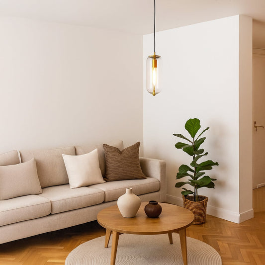 Modern pendant light with gold finish and cylindrical glass shade styled in living room for elegant hanging ceiling lighting.