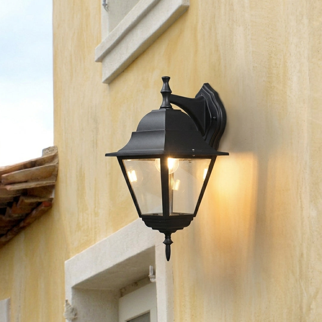 Black metal outdoor lantern wall light lifestyle image with warm glow for elegant exterior entryway decor.
