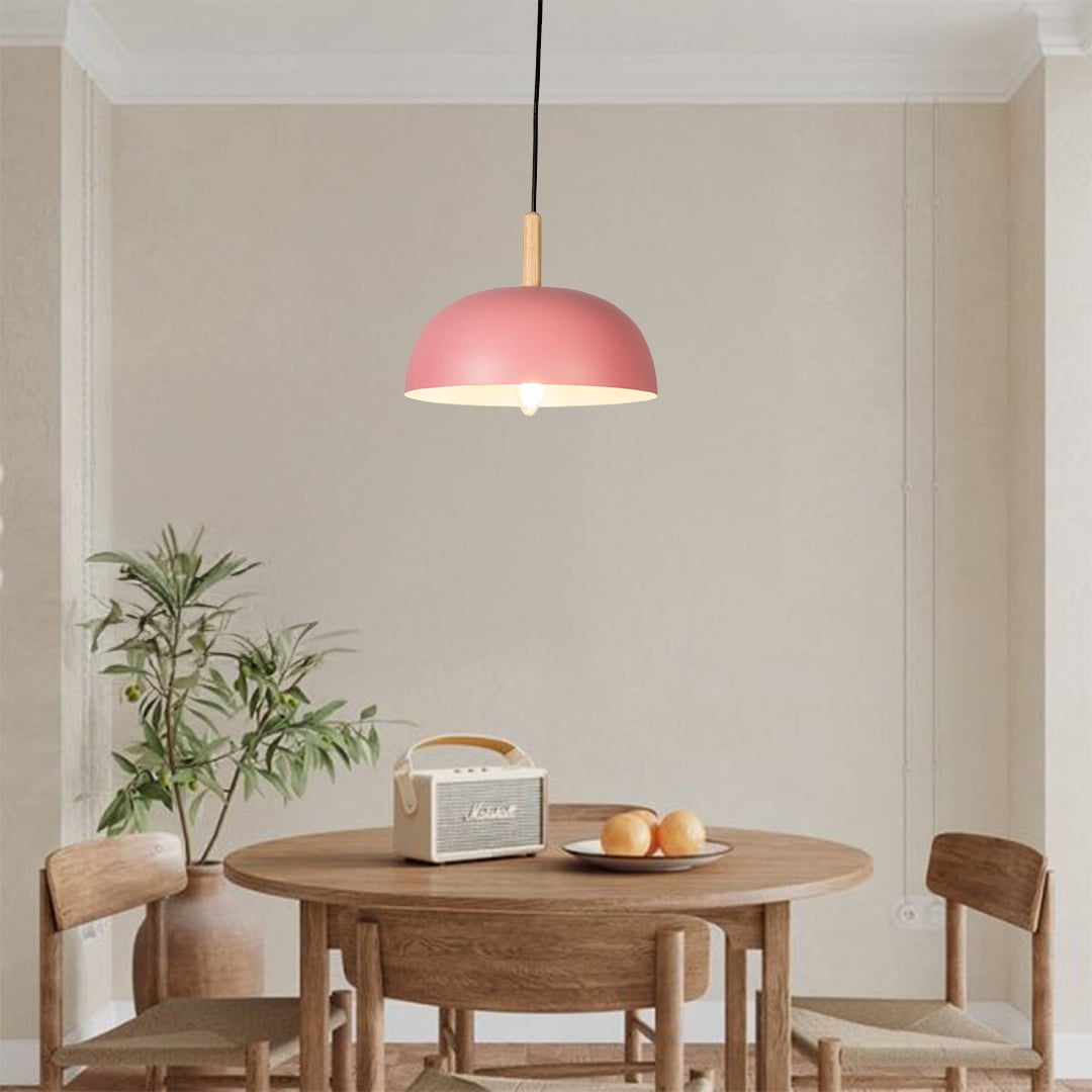 Pink metal pendant light above dining table adding soft Scandinavian charm and warm ambient lighting to interiors.