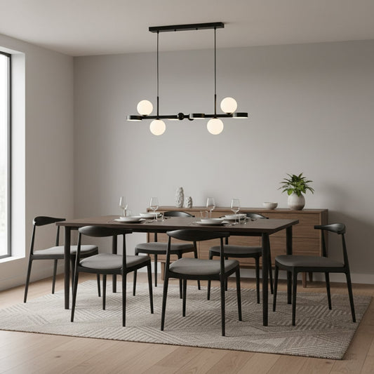 Black metal chandelier with white globe lights illuminating a modern dining room creating a sleek minimal and warm contemporary interior atmosphere.