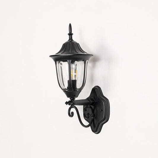 black outdoor wall sconce turned off on white background showcasing upward lantern with clear glass vintage coach style.