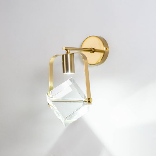 Gold metal crystal wall light on white background with geometric glass shade for luxury modern wall decor.