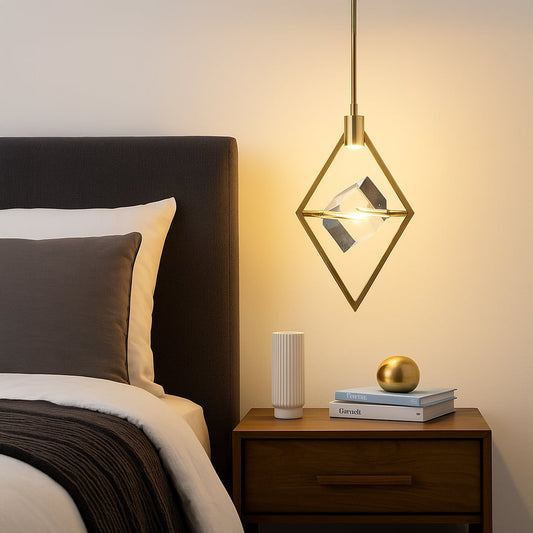 Pendant light with golden diamond frame and crystal centerpiece glowing beside bed in modern bedroom decor.