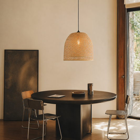 A woven wicker pendant light hangs over a round dark wood dining table in a modern, sunlit room with chairs and a large window.