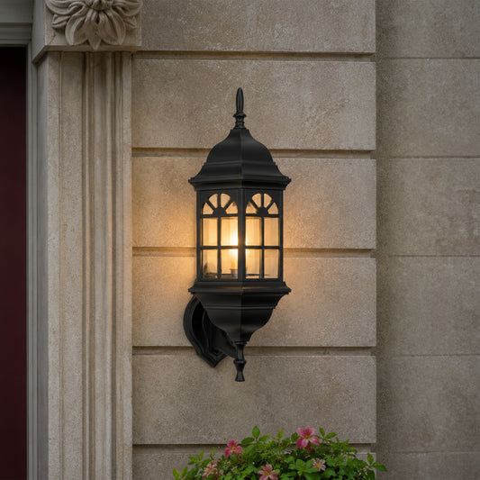 Black metal outdoor wall light lifestyle image with arched paneled glass shade mounted on an elegant stone column.
