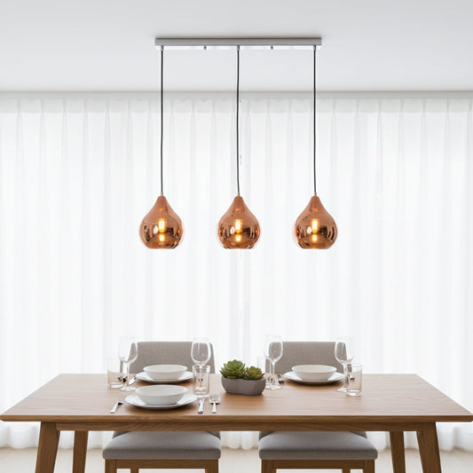 Amber glass pendant lights creating warm ambience above the dining table in modern interiors.