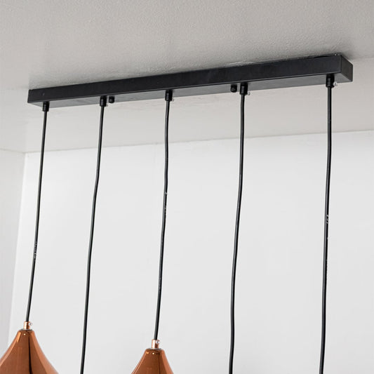 Close view of copper teardrop pendant lights showing smooth reflective metal surfaces and sculpted modern shapes for refined interior lighting.