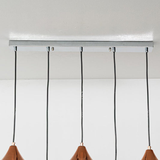 Close view of copper teardrop pendant lights highlighting their smooth reflective metal finish and sculpted modern shape for premium interior lighting.