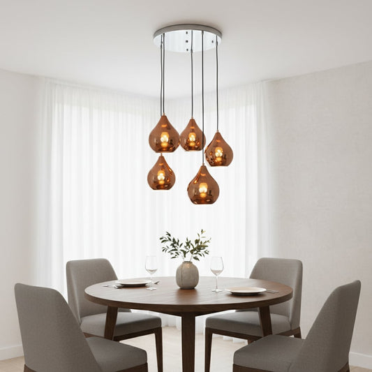 Modern copper pendant cluster with five glossy teardrop shades hanging from a silver ceiling plate creating a warm elegant focal point in the room.