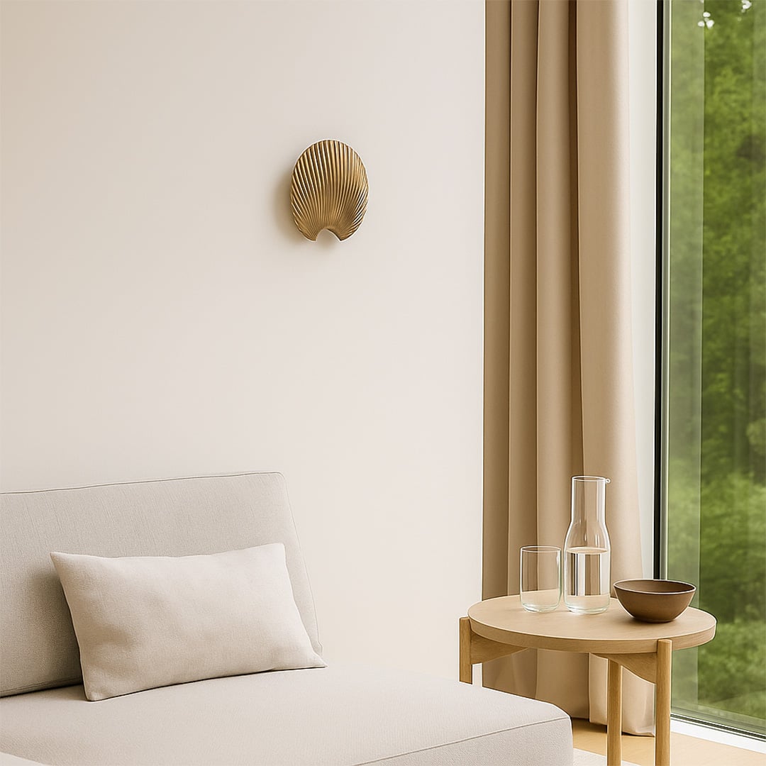 A gold decorative shell piece displayed on a clean wall creating a minimal lifestyle look with soft shadows and a modern sculptural feel that enhances elegant home styling.