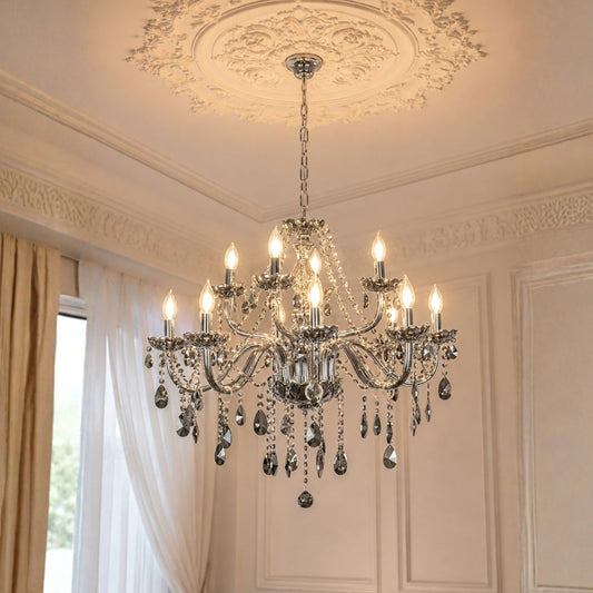 An ornate silver crystal chandelier with multiple candle-style lights hanging from a decorative ceiling medallion in a classic interior room.