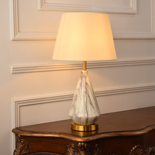 White marble table lamp with fabric shade placed on a wooden console table creating elegant ambient lighting indoors.