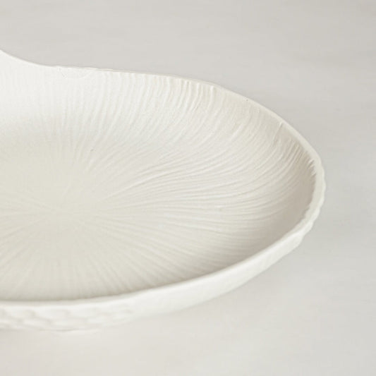 White ceramic fruit serving bowl with elegant textured shell surface showing modern decorative centerpiece for dining table decor.