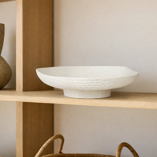 White ceramic pedestal fruit bowl with textured shell design for dining table centerpiece and modern kitchen decor display.