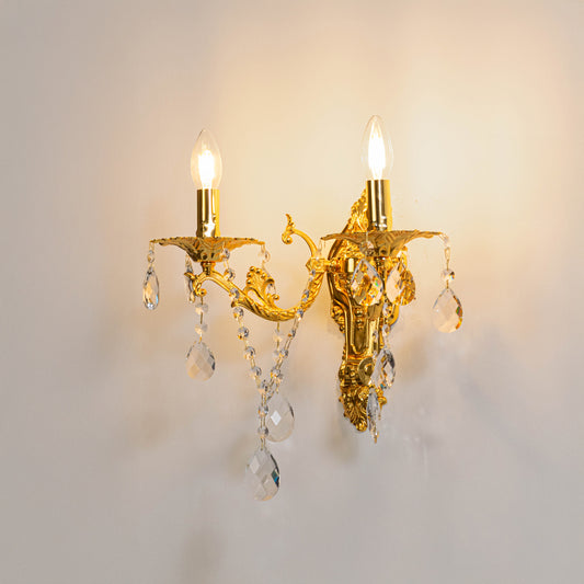 Gold metal crystal wall light on white background with candle style bulbs for elegant vintage wall decor.