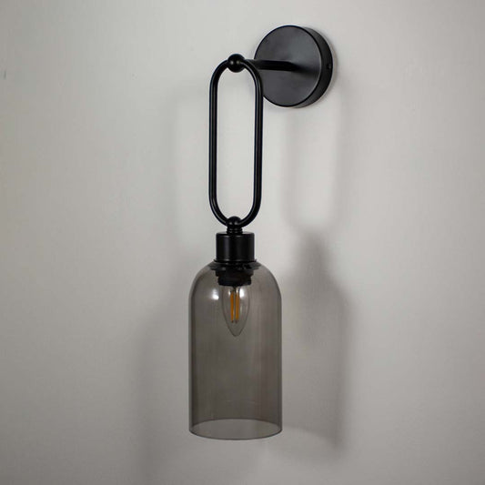 Modern black metal wall light with smoked glass shade for elegant bedroom and contemporary decor styling spaces.