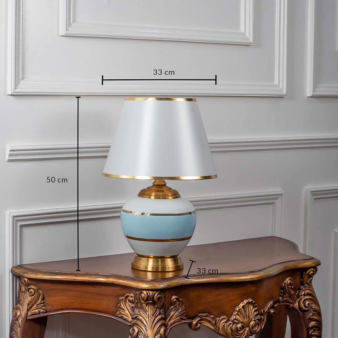 Designer ceramic and metal table lamp measuring 50 cm in height and 33 cm in width featuring a modern blue and white body with gold accents.