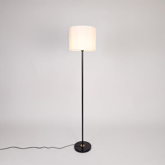 Black metal floor lamp with white fabric drum shade designed for elegant living room and bedroom lighting decor.