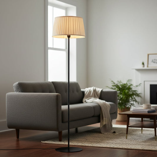 Modern black metal floor lamp with pleated cream fabric shade placed in living room corner for warm ambient lighting Decor.