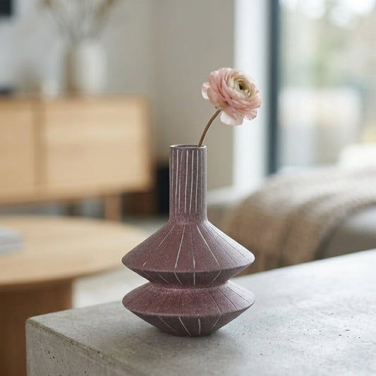 Pink ceramic decorative flower vase placed on table with flower modern aesthetic home decor styling idea.