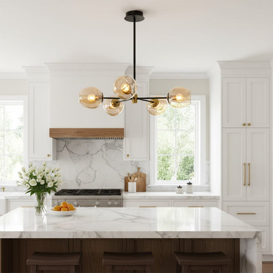 Modern chandelier with glass globe lights in gold finish hanging above kitchen island adding warm ambient lighting to elegant home interior.