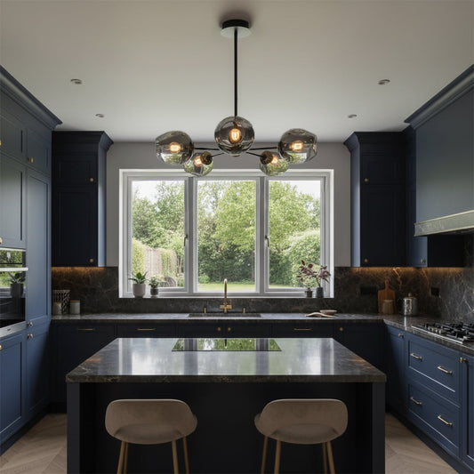 Contemporary chandelier with metal frame and glass globes suspended over kitchen island creating balanced illumination and refined decor style.