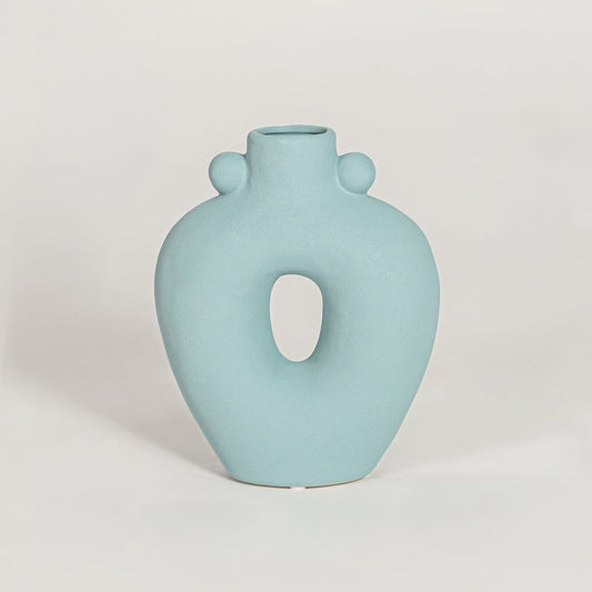 Contemporary light blue ceramic flower vase with abstract cutout shape perfect for entryway table living room decor display.