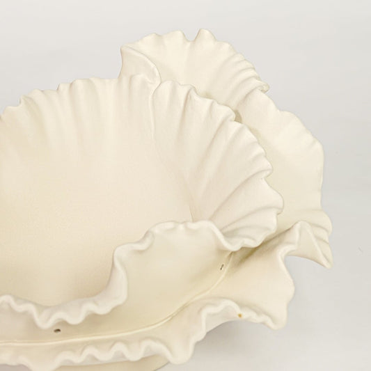 Close view of white ceramic ruffled decorative bowl highlighting layered floral edges and smooth matte finish.