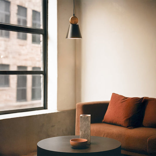 Modern metal pendant light with black shade and round metal accent creating focused warm illumination ideal for contemporary interior home decor styling.