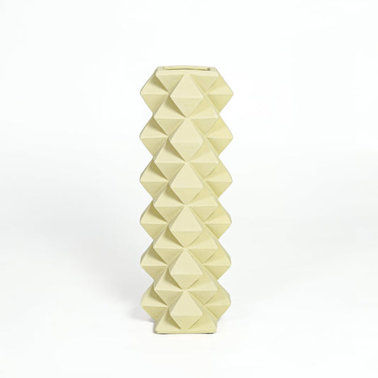 Contemporary yellow ceramic flower vase with sculpted diamond design isolated on white background.