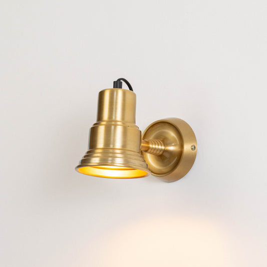 Classic metal wall light in gold finish with angled shade for indoor or outdoor accent lighting decor placement white background.