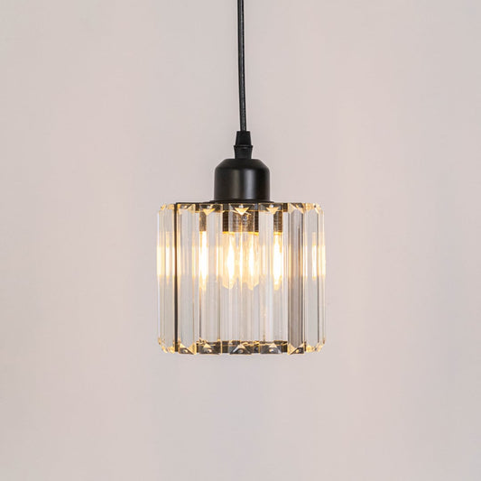 Clear ribbed glass pendant light with warm glow and black frame adding elegant ambient lighting for interiors.
