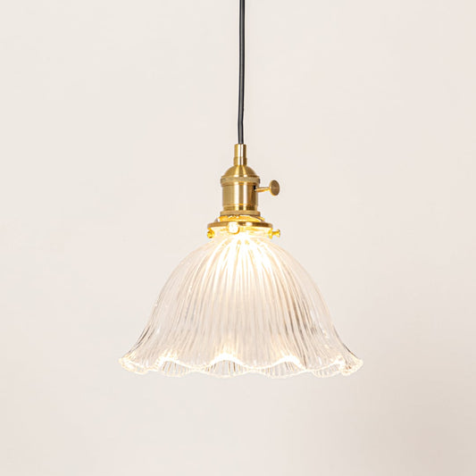 Fluted clear glass and brass metal pendant light designed for stylish dining room decor spaces.