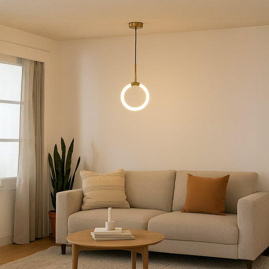 Modern gold pendant light glowing warmly above a cozy beige sofa in a minimalist living room interior decor.