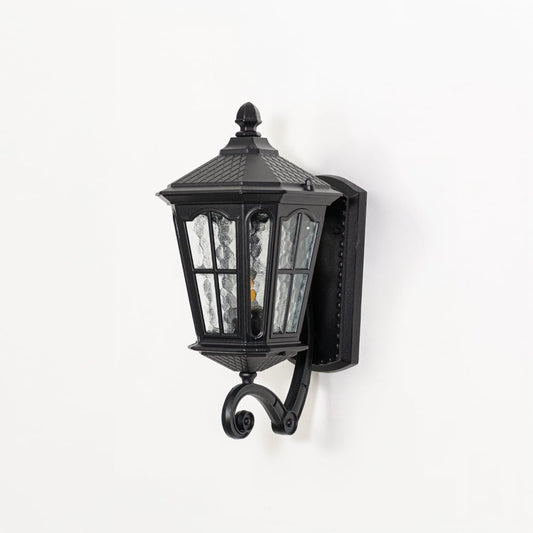 Outdoor wall lantern in black metal switched off on white background highlighting textured glass panels and classic lantern form.