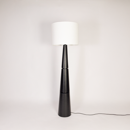 Floor lamp off on white background displaying tall textured black base with wide white drum shade for minimalist interior styling homes feel now.