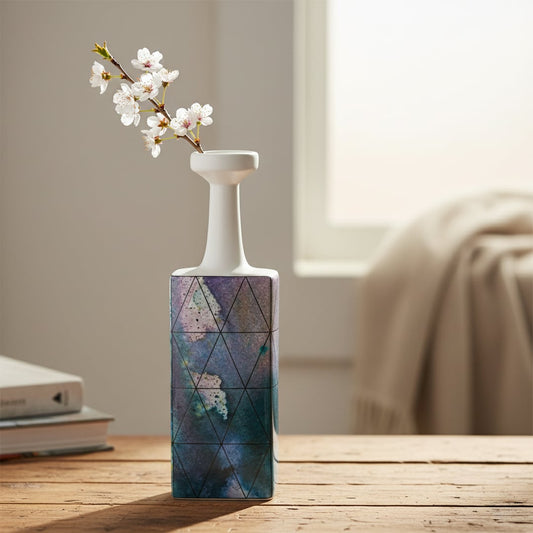 White and purple ceramic flower vase with white blooms placed on wooden table for stylish decor styling.