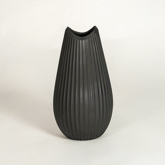 Sleek matte black ribbed vase with modern silhouette for minimalist home decor and elegant living room centerpieces.