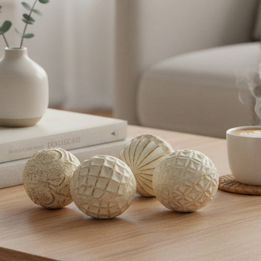 Textured ceramic balls set styled on a wooden coffee table beside a cup of coffee and books in a cozy minimal living room.
