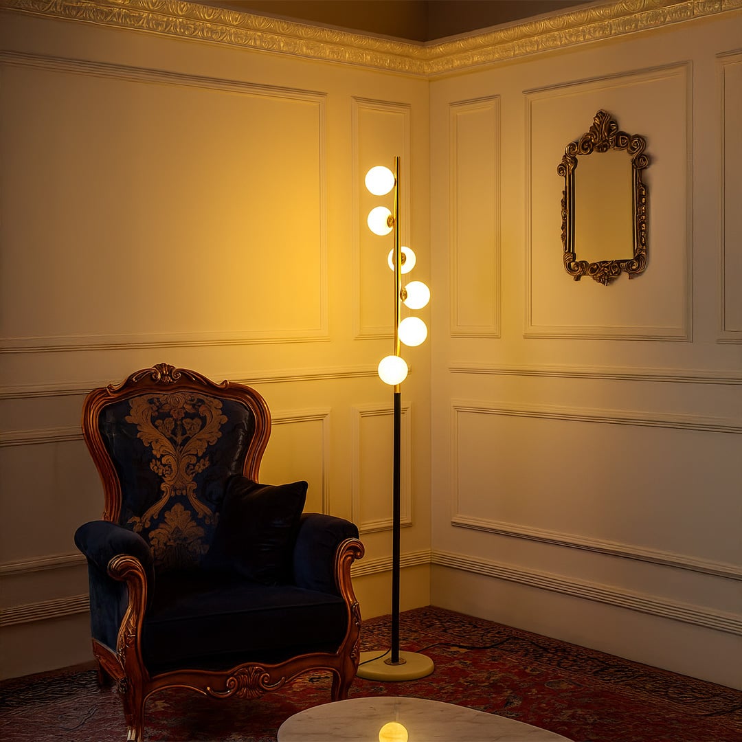Elegant globe floor lamp turned on in a luxurious living room with vintage chair and classic wall paneling.