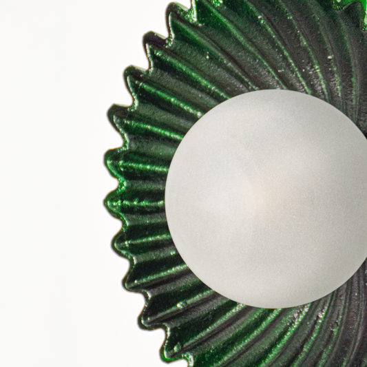 Wall light closeup highlighting textured green metal ripple design with smooth frosted glass globe showcasing premium craftsmanship and elegant finish.